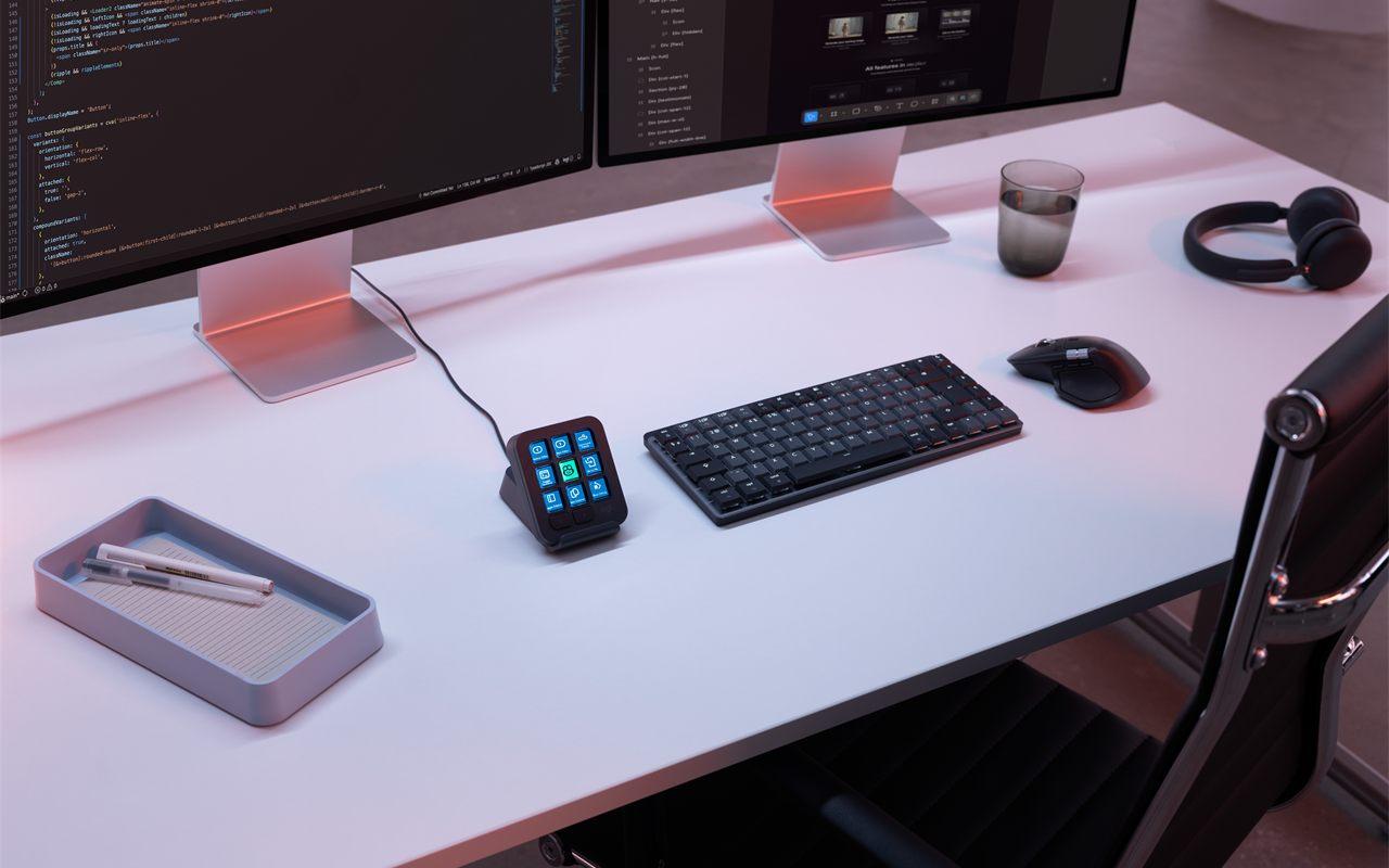 Le Logitech MX Keypad Graphite posé entre le clavier et deux écrans de code