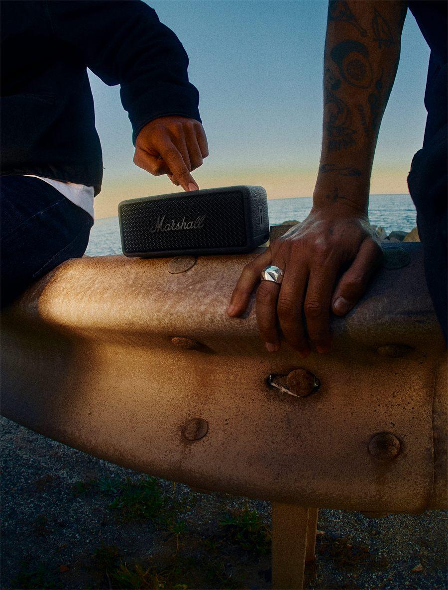 Marshall Emberton III Pitch Black posee sur une rambarde face a la mer au crepuscule