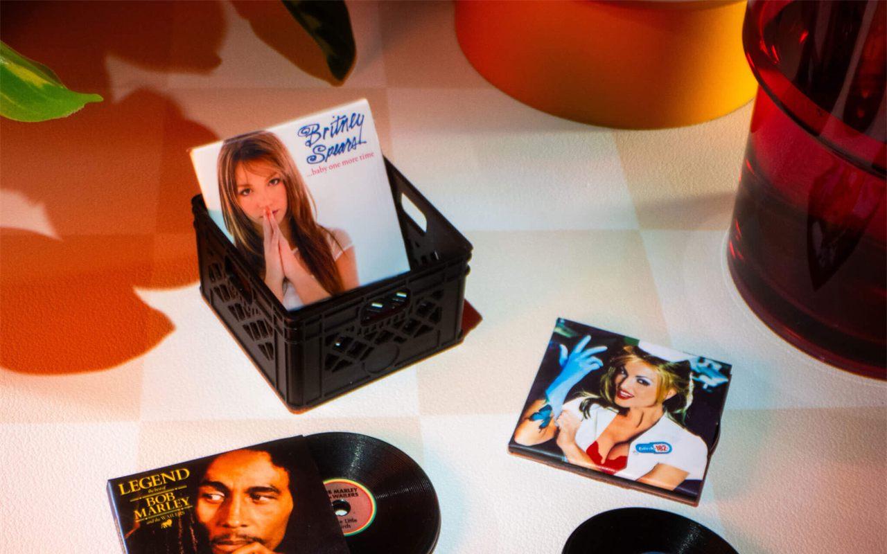Mini-vinyles Britney Spears, blink-182 et Bob Marley près d'une caisse ajourée