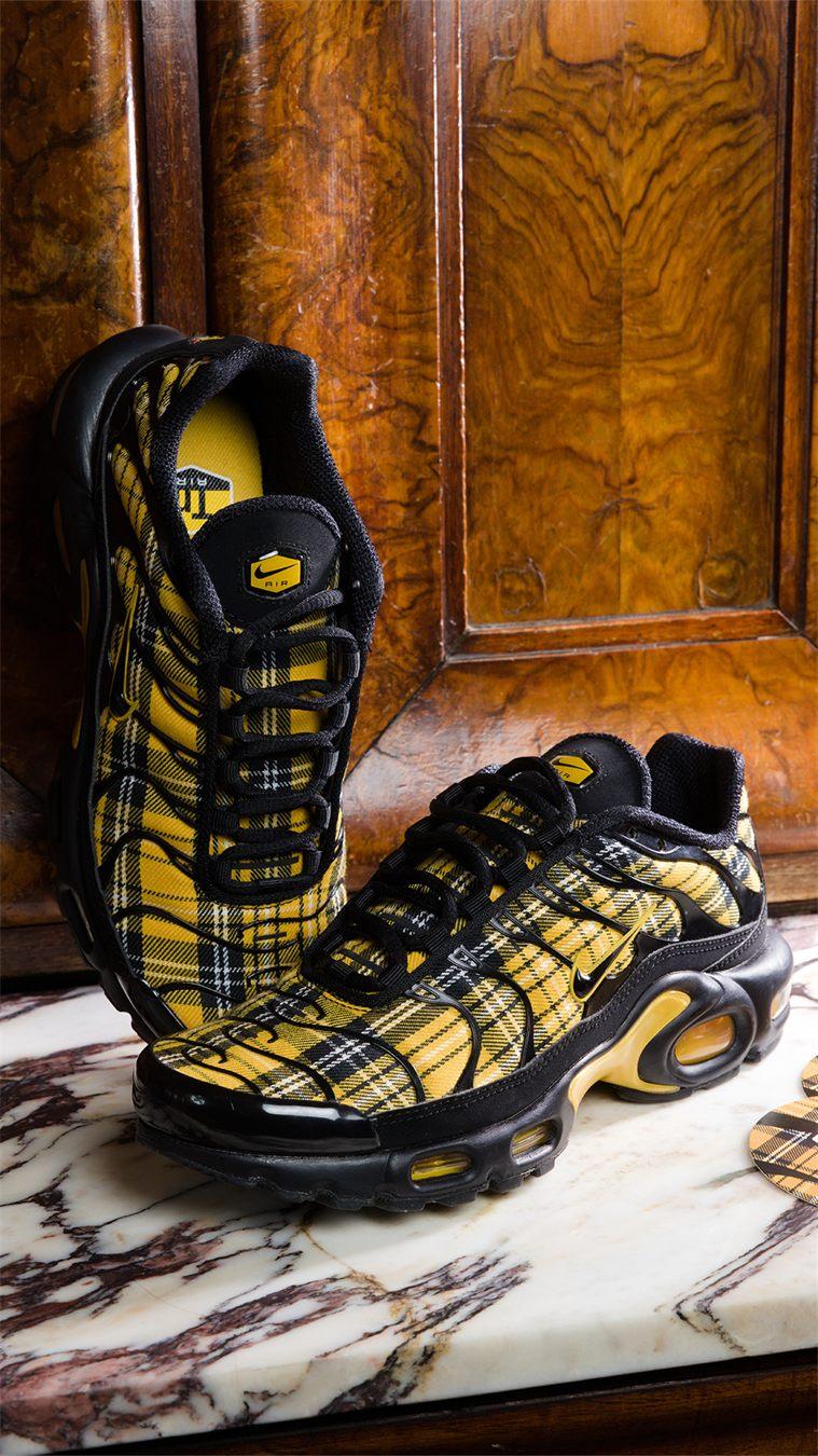 Paire de Nike TN Tartan sur du marbre, languette noire et semelle intérieure à carreaux