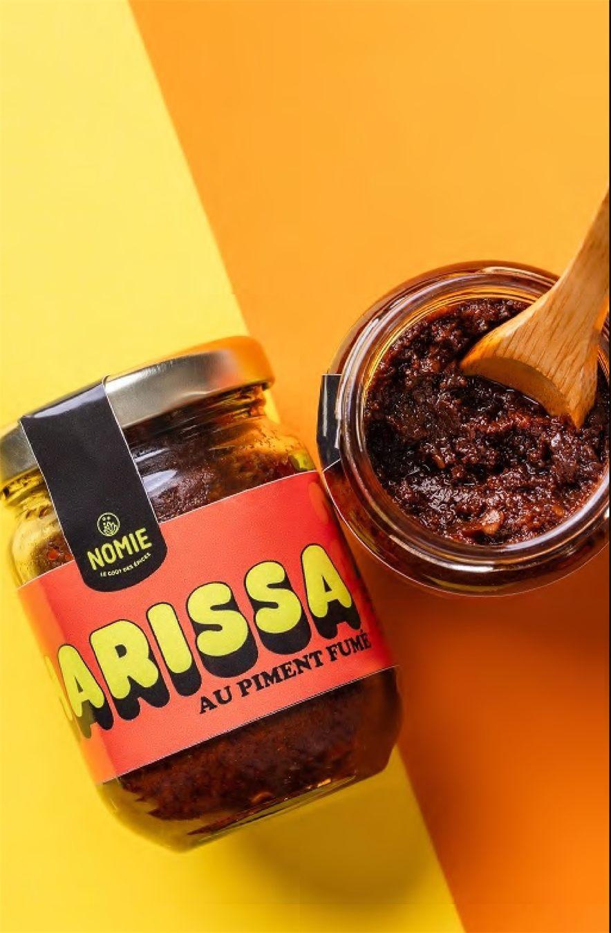 Bocal de harissa au piment fumé Nomie ouvert avec une cuillère en bois