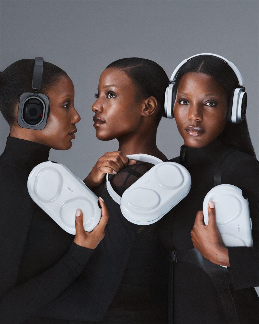 Trois femmes tiennent l'étui rigide blanc du casque Nothing Headphone (1) Pro
