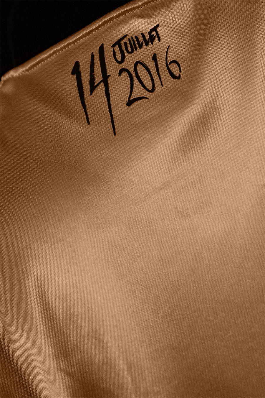 La date du 14 juillet 2016 calligraphiée sur le tissu doré du maillot de l'OGC Nice