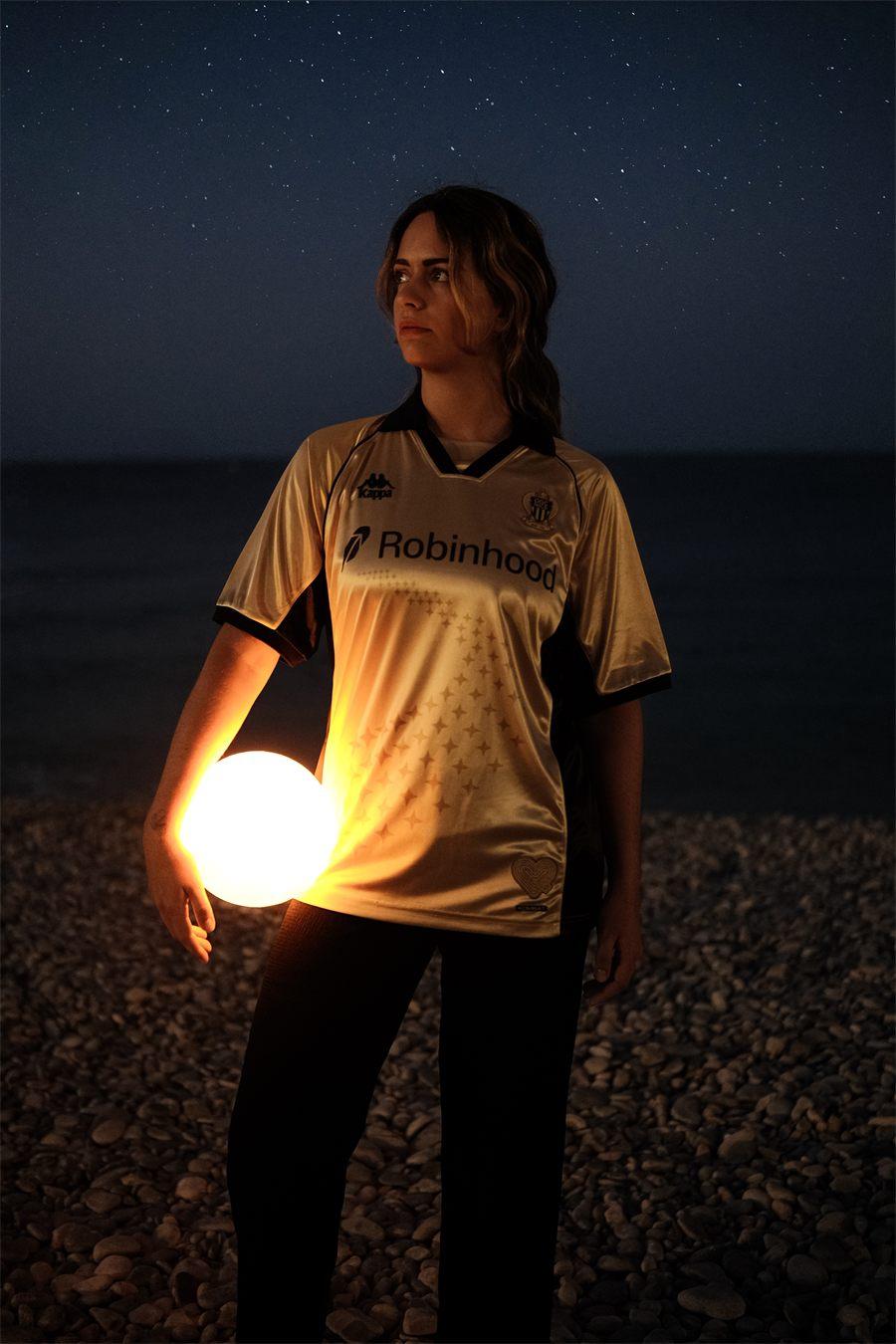 Le maillot hommage de l'OGC Nice porté de nuit, sous un ciel étoilé, près d'une boule lumineuse