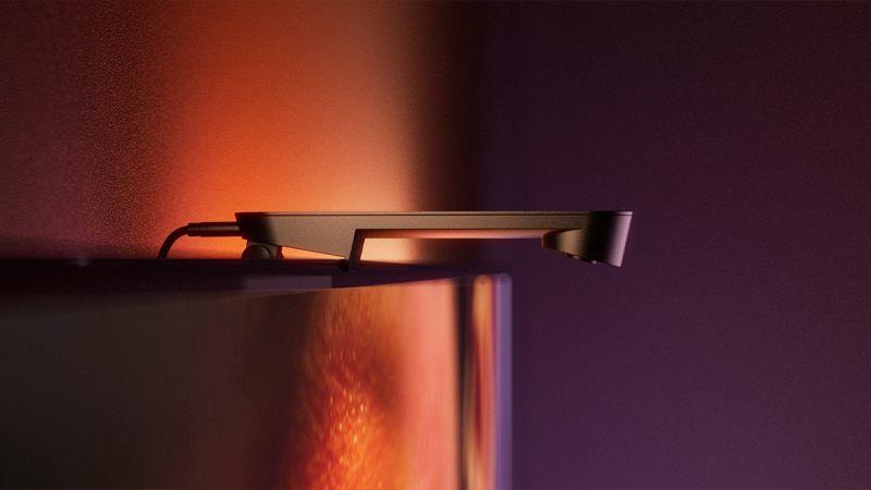 Caméra Philips Hue Play Screen Sync posée à cheval sur le bord haut de l'écran