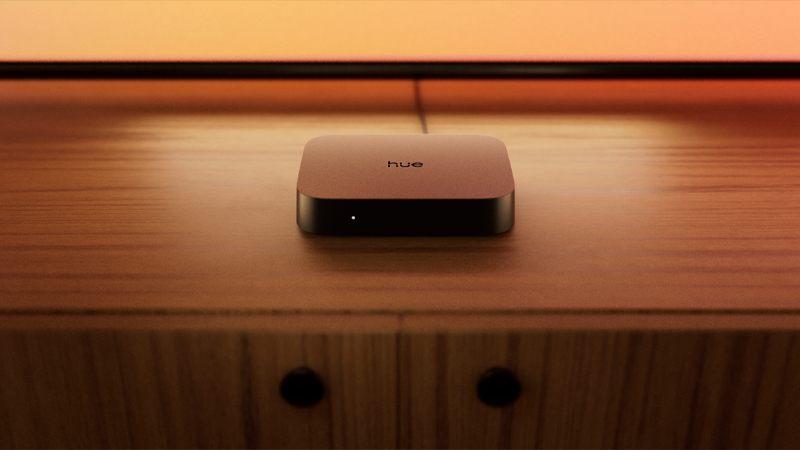 Boîtier de synchronisation HDMI Philips Hue Play 4K posé sur un meuble en bois