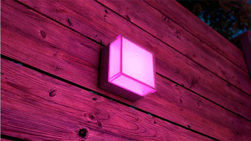 Applique murale extérieure Philips Hue Scenova allumée en rose sur un bardage bois