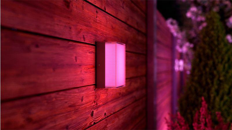 Applique murale extérieure Philips Hue Semeru allumée en rose sur un bardage bois
