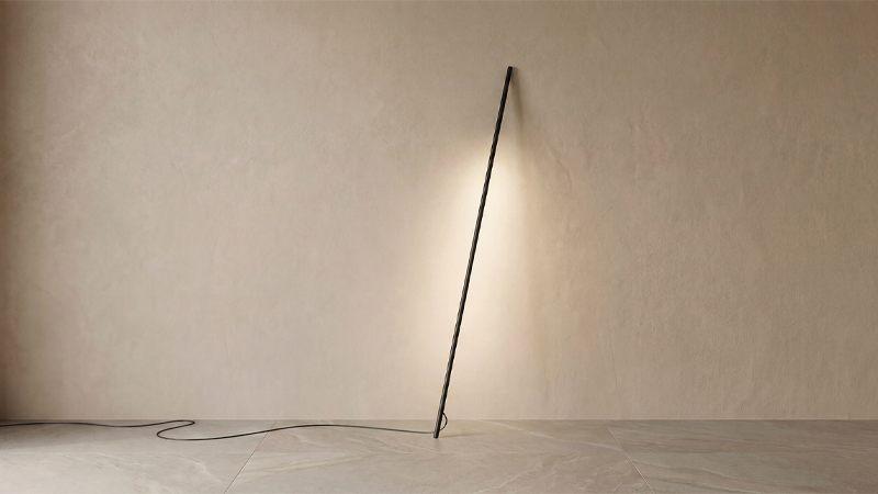 Philips Hue Signe Pole appuyé en oblique contre un mur qu'il éclaire