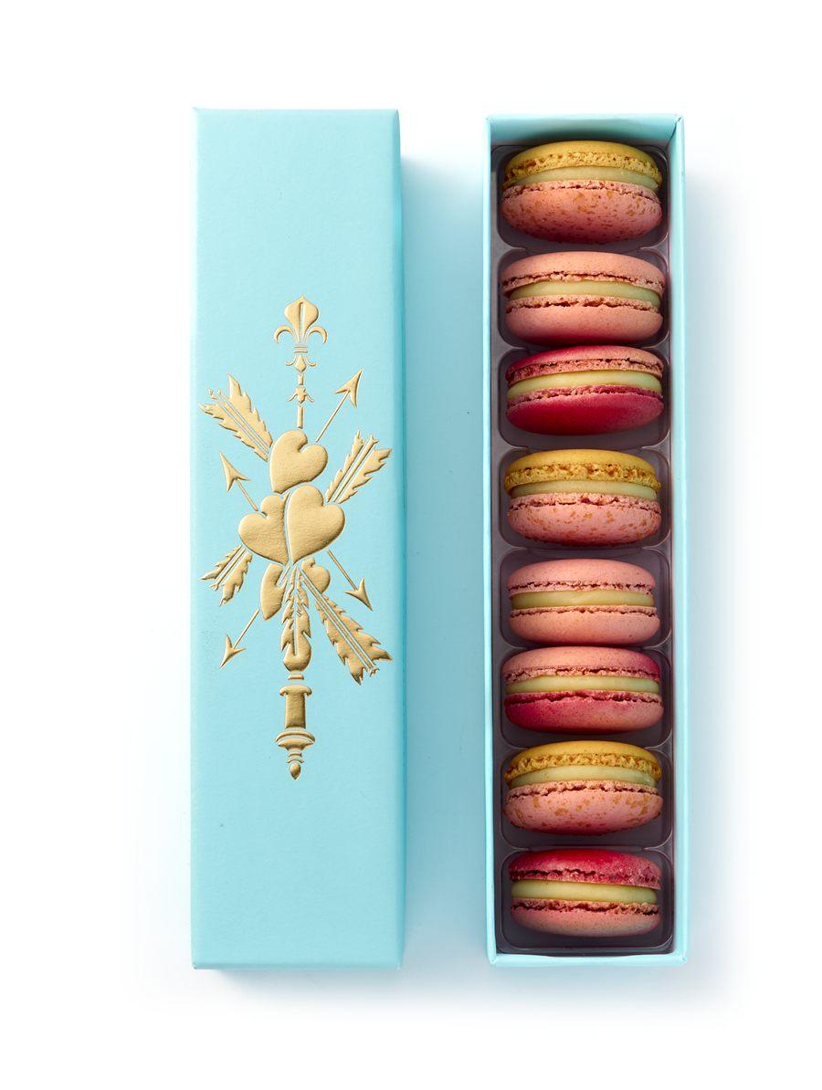Les huit macarons du coffret Marie-Antoinette alignés en une file, couvercle posé à côté