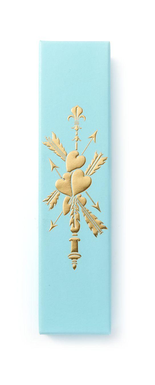 Couvercle bleu du coffret Pierre Hermé x Sofia Coppola, deux cœurs percés de flèches sous une fleur de lys