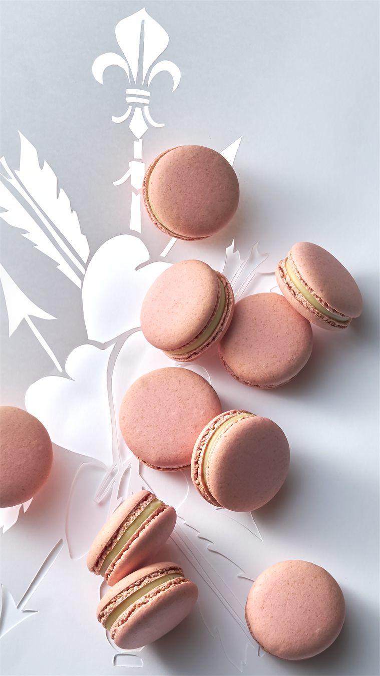 Macarons Antigone rose pâle sur le décor de cœurs et de flèches du coffret Marie-Antoinette