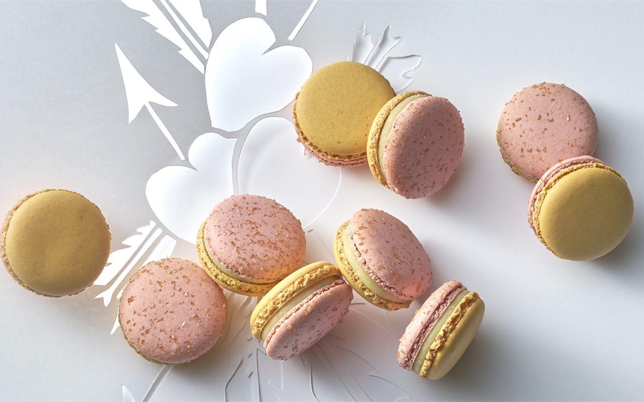 Macarons Vénus de Pierre Hermé, coques roses sucrées et coques jaunes mêlées sur le décor du coffret