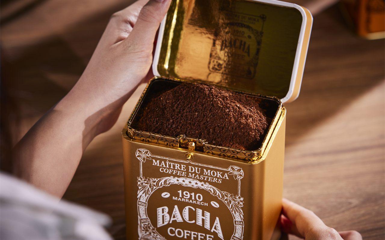 Boîte dorée de Grand Moka Matari ouverte sur le café moulu