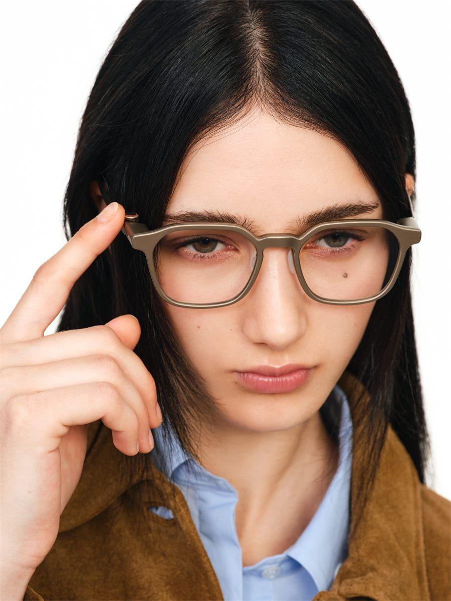 Femme portant les lunettes RayNeo iO, doigt posé sur la branche