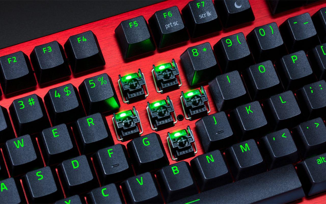 Plaque en aluminium rouge et switches optiques Razer visibles sous les touches noires retirées