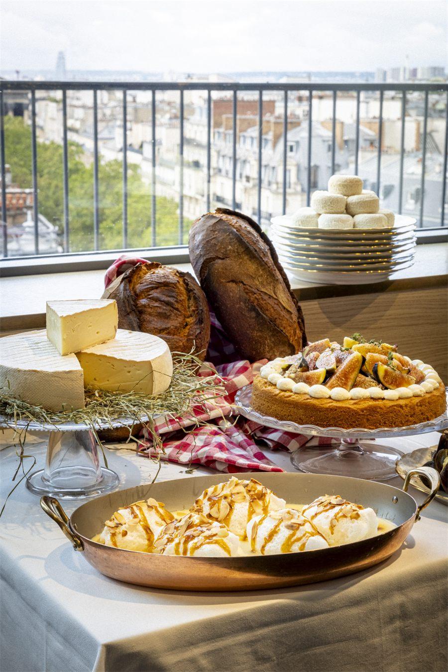 Fromages, pains et tarte aux figues devant les toits de Paris