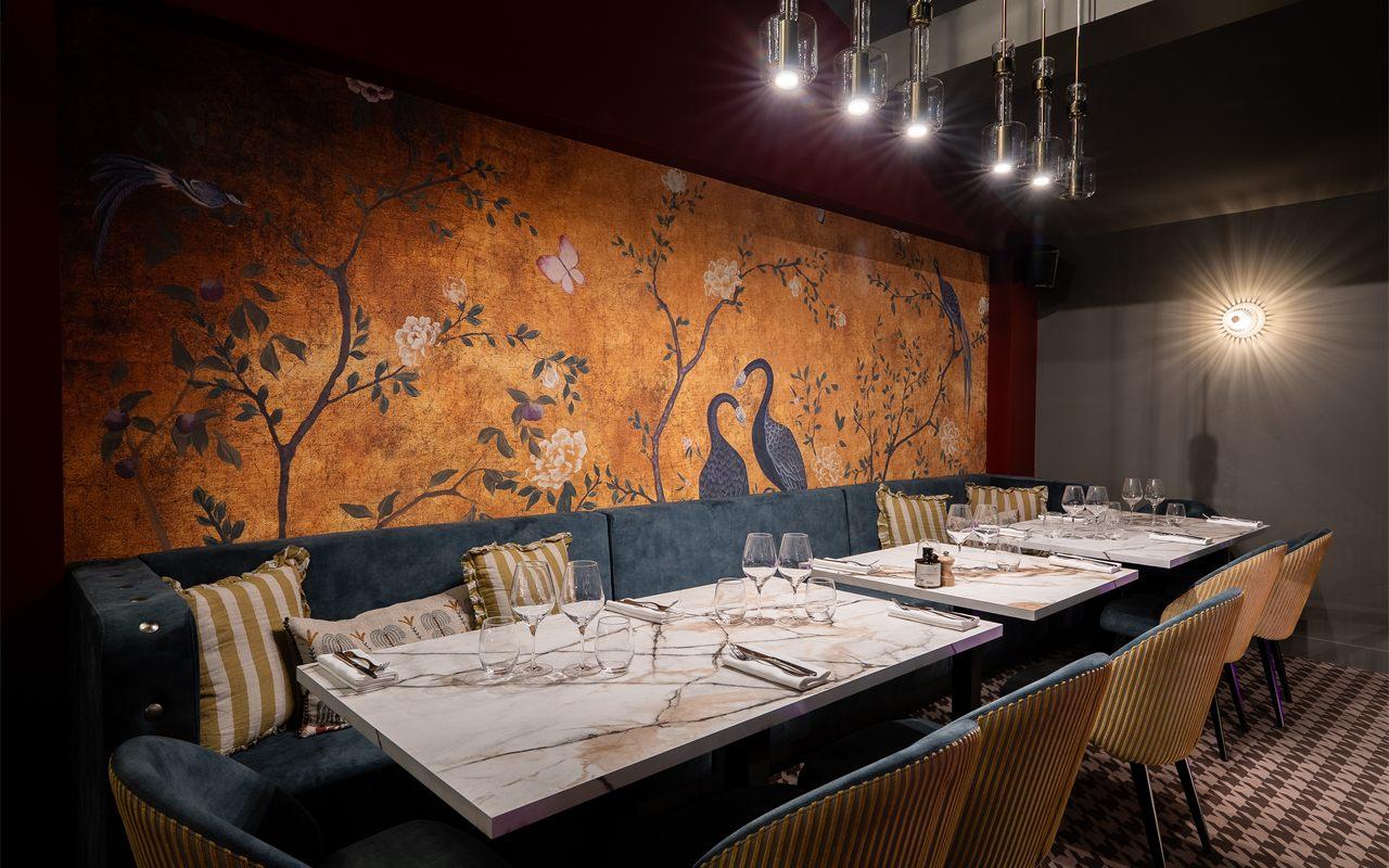 Banquette de velours et fresque florale dans un coin de La Bokka