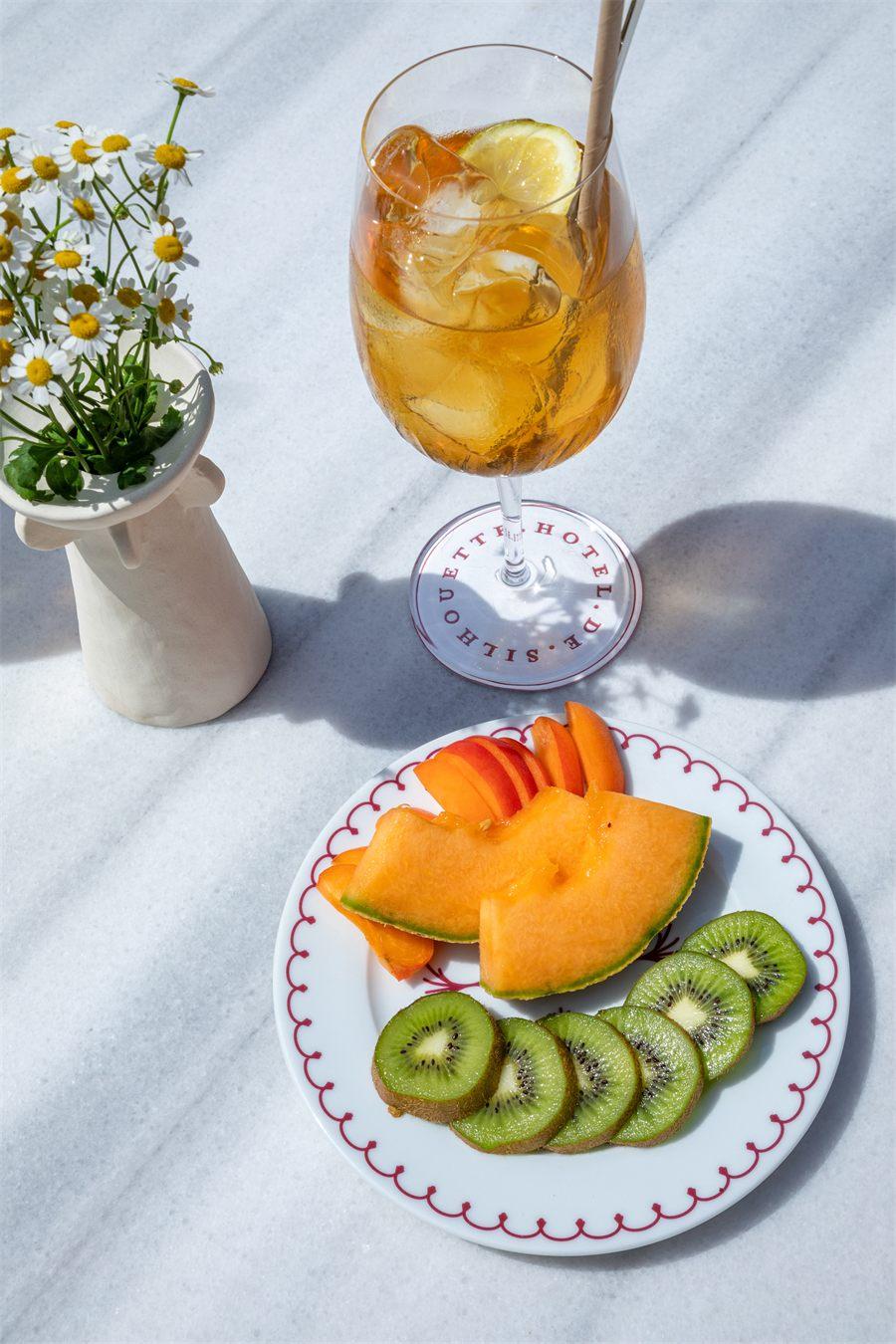Assiette de melon et de kiwi et verre gravé au nom de l'Hôtel de Silhouette