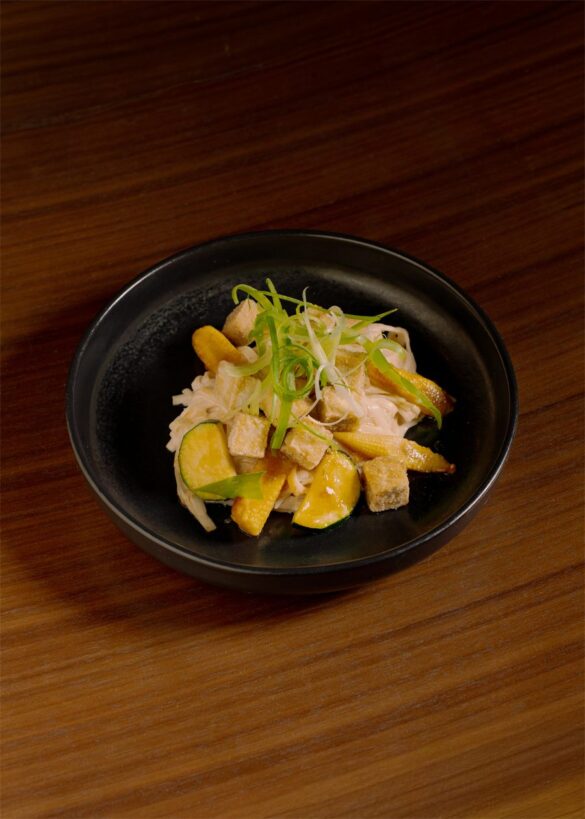restaurant-sobo-bol-de-tofu-nomadeurbain Bol noir garni de tofu, de courge et de cebette, pose sur une table en bois chez SOBO