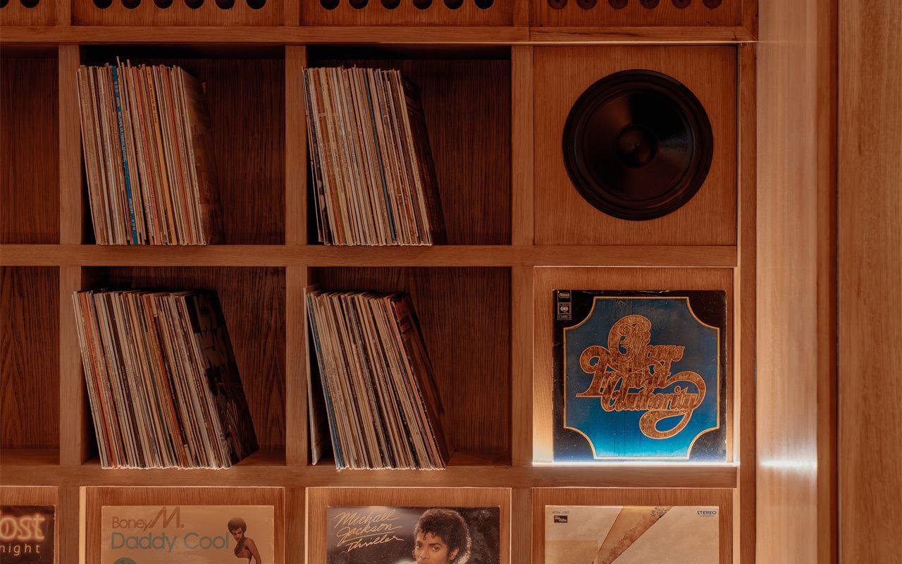 Cloison en chene garnie de vinyles et d'un haut-parleur encastre dans la salle de SOBO