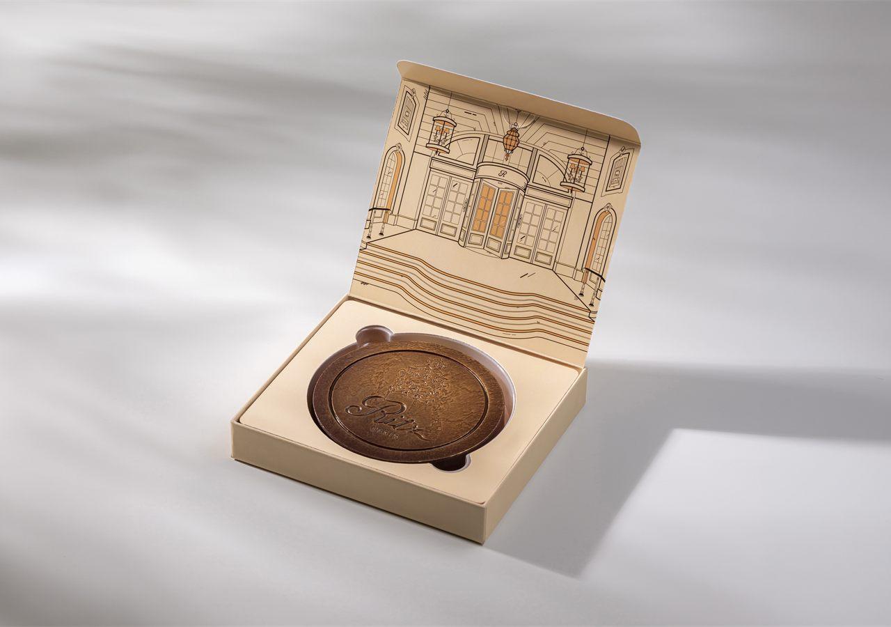 Le Camée en chocolat noir reprend le blason du Ritz Paris, dans son coffret illustré