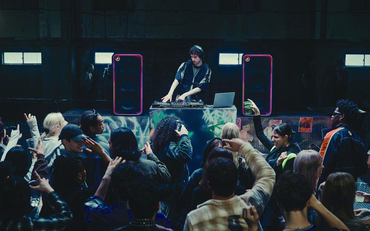 Un DJ mixe entre deux enceintes Sony ULT TOWER MAX devant une foule qui danse
