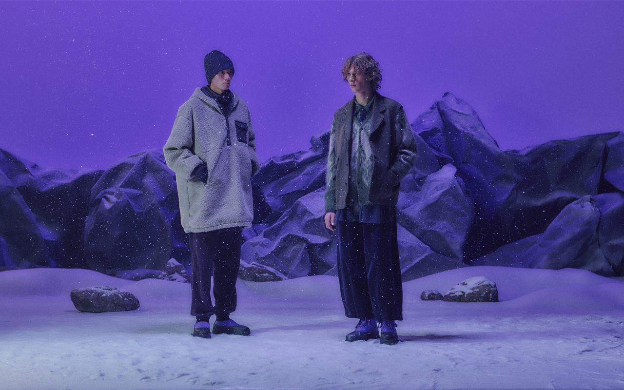 Deux mannequins portant la collection SOREL x NEEDLES dans un décor de neige éclairé en violet