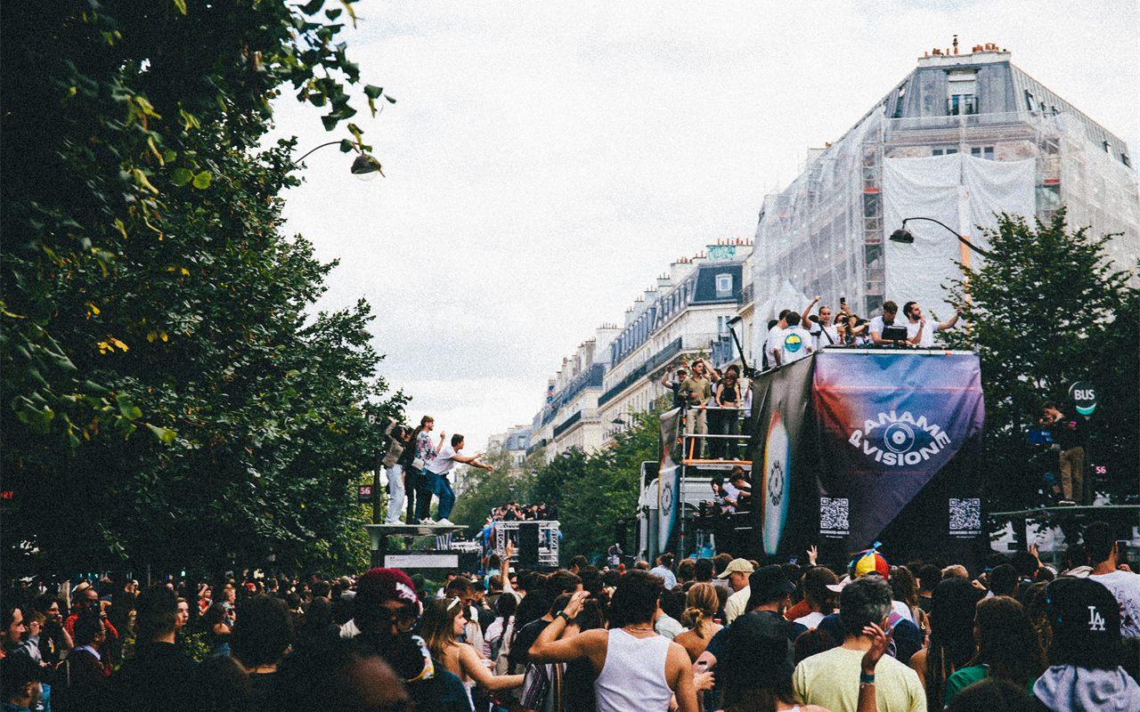Char de la Techno Parade avec ses DJ aux platines sur un boulevard parisien