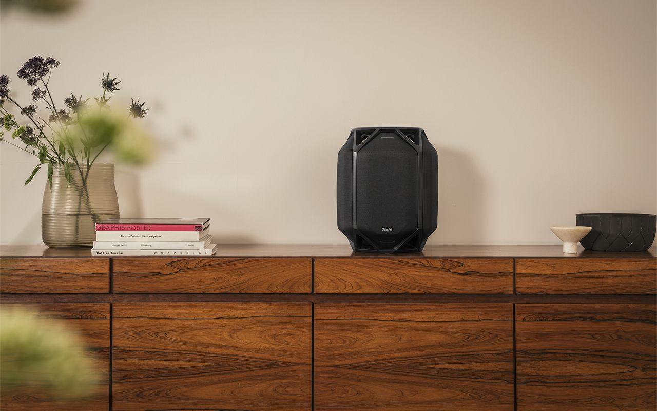 Teufel IKONIO habillé de ses caches en tissu, posé sur une enfilade en palissandre