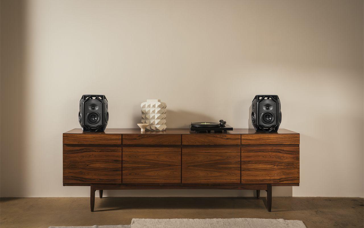 Paire de Teufel IKONIO posée aux deux extrémités d'une enfilade, platine vinyle au centre