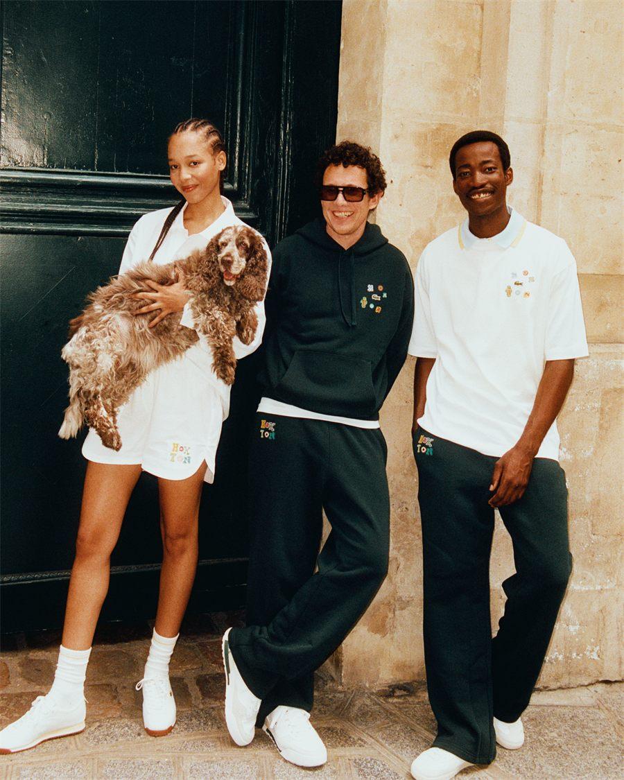 Trois silhouettes de la collection The Hoxton x Lacoste devant la facade de l'hotel