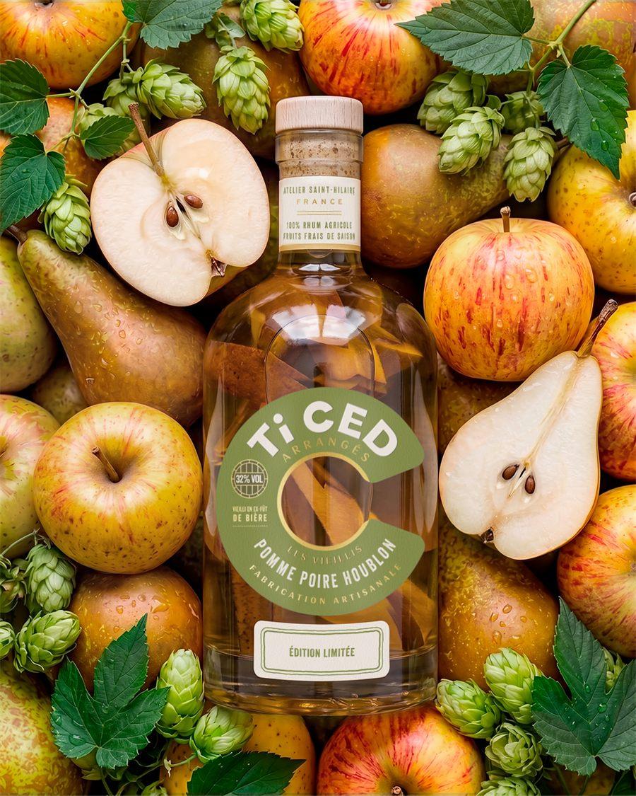 Bouteille Ti CED Pomme Poire Houblon entourée de pommes, de poires et de cônes de houblon