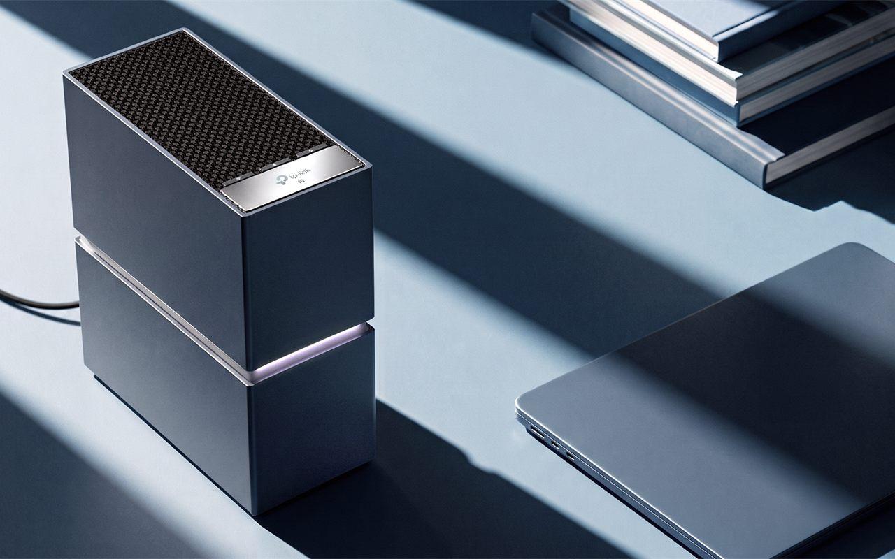 Le routeur TP-Link Archer 8 Ultra posé sur un bureau à côté d'un ordinateur portable