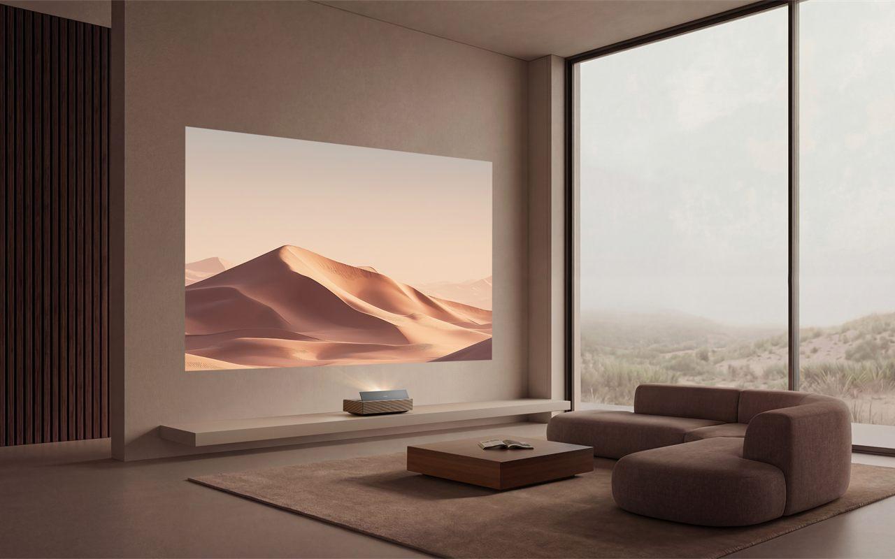 Le XGIMI AURA 3 Max projette des dunes dans un salon éclairé par une baie vitrée