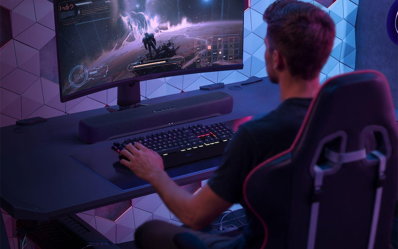 Un joueur devant un écran incurvé, la Yamaha B200A posée sous le moniteur
