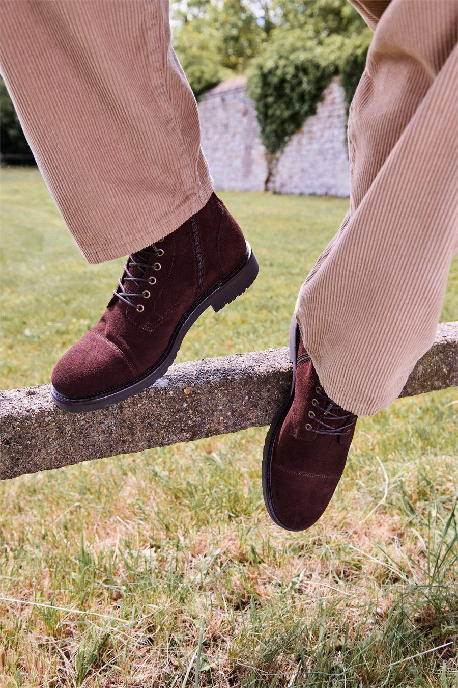Boots Samuel en chocolat posées sur une clôture, pantalon en velours côtelé