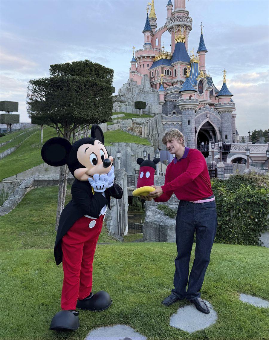 Mickey, mains sur les joues, face à Gustaf Westman à Disneyland Paris
