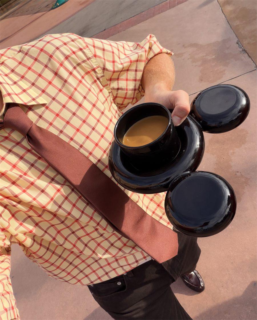La tasse Mickey remplie de café, tenue à Disneyland Paris