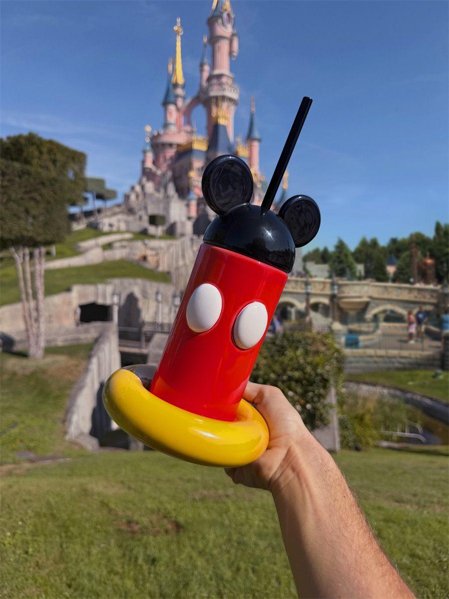 Le Tumbler Mickey tenu devant le château de la Belle au bois dormant à Disneyland Paris