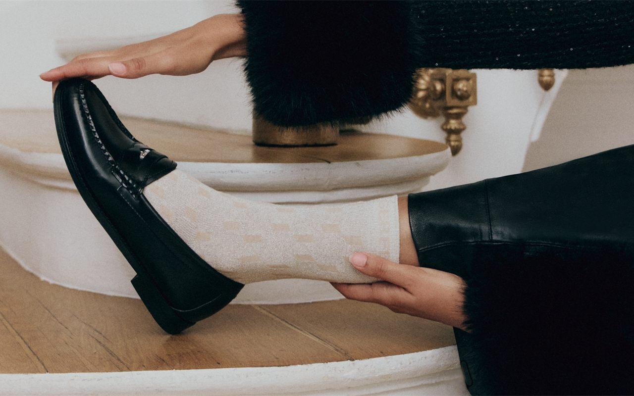 Avec G.H.Bass x Karl Lagerfeld, le mocassin sage des campus américains vous adresse un clin d&rsquo;œil insolent, signé du couturier en lettres argentées.