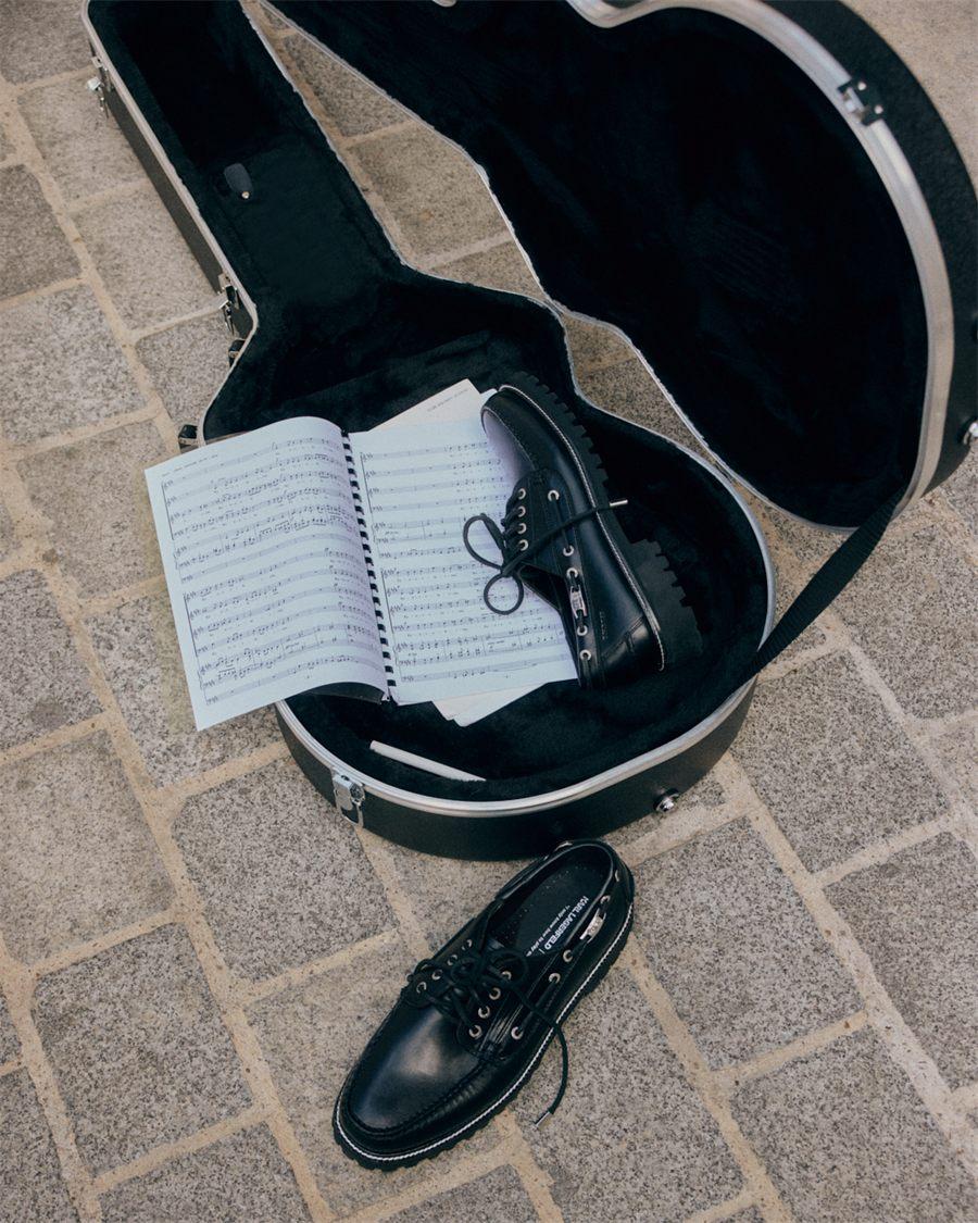 Mocassin lacé Ranger Camp Moc à semelle crantée près d'un étui de guitare