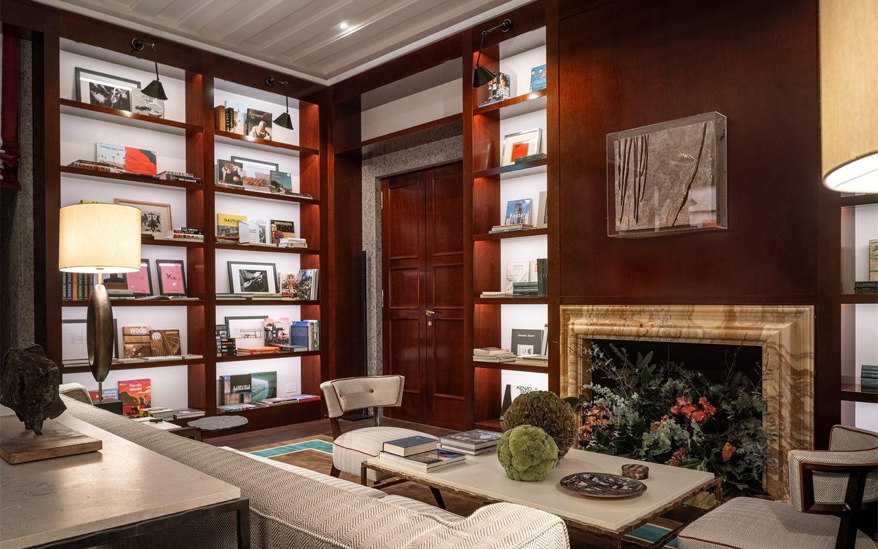 La bibliothèque de l'hôtel Portrait Milano, sa cheminée et ses rayonnages de livres