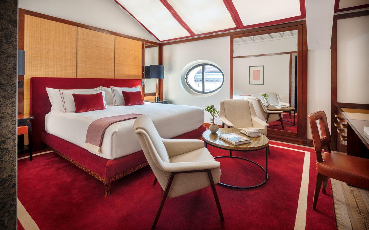 Chambre de l'hôtel Portrait Milano en rouge et bois, décor de Michele Bönan