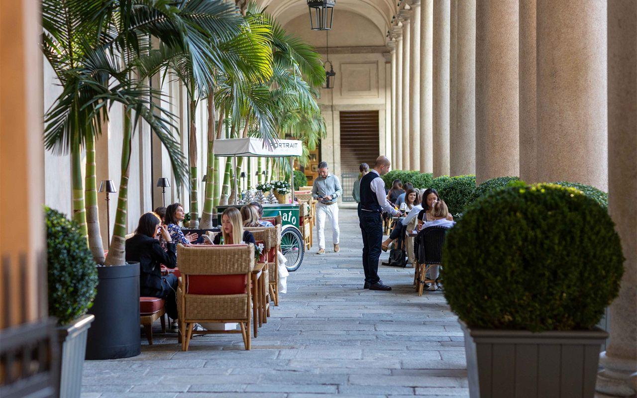 Tables dressées sous la colonnade de la Piazza de l'hôtel Portrait Milano