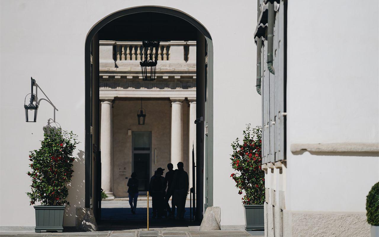 Des passants franchissent l'entrée de la Piazza de l'hôtel Portrait Milano