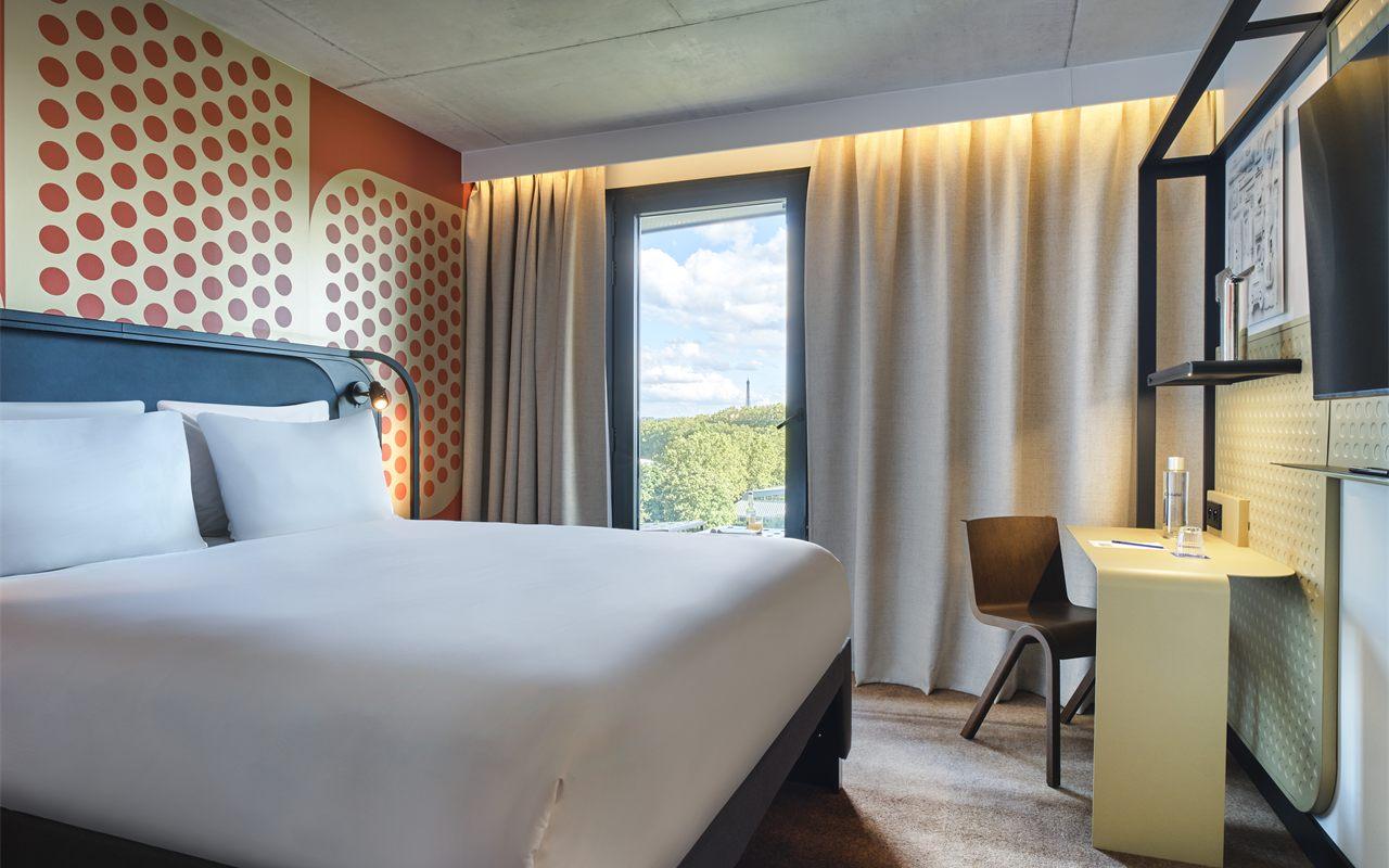 Chambre aux murs à pois orange, tour Eiffel visible par la fenêtre