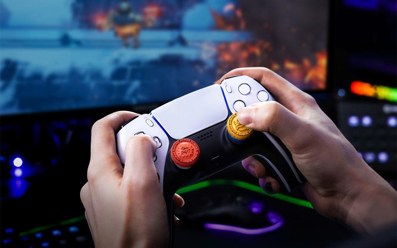 Manette PS5 équipée des rehausseurs Durrr Burger KontrolFreek, devant un écran de jeu