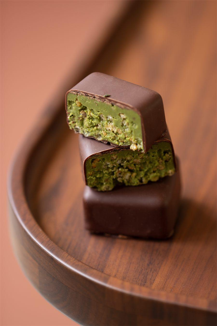 Chokoshi au matcha coupé, praliné au riz soufflé sous son enrobage de chocolat noir
