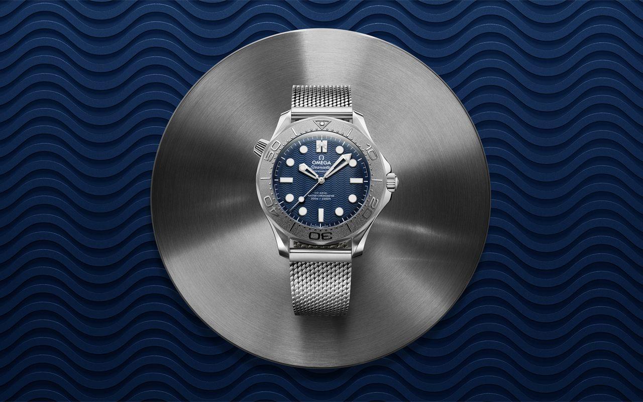 Seamaster Diver 300M Édition James Bond sur bracelet milanais, posée sur un fond à vagues bleues